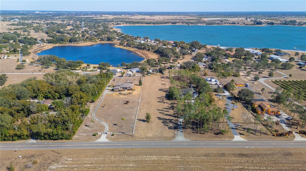 An aerial view shows two adjacent residential lots bordering a road near a large lake — 0 S SCENIC HWY, LAKE WALES, FL