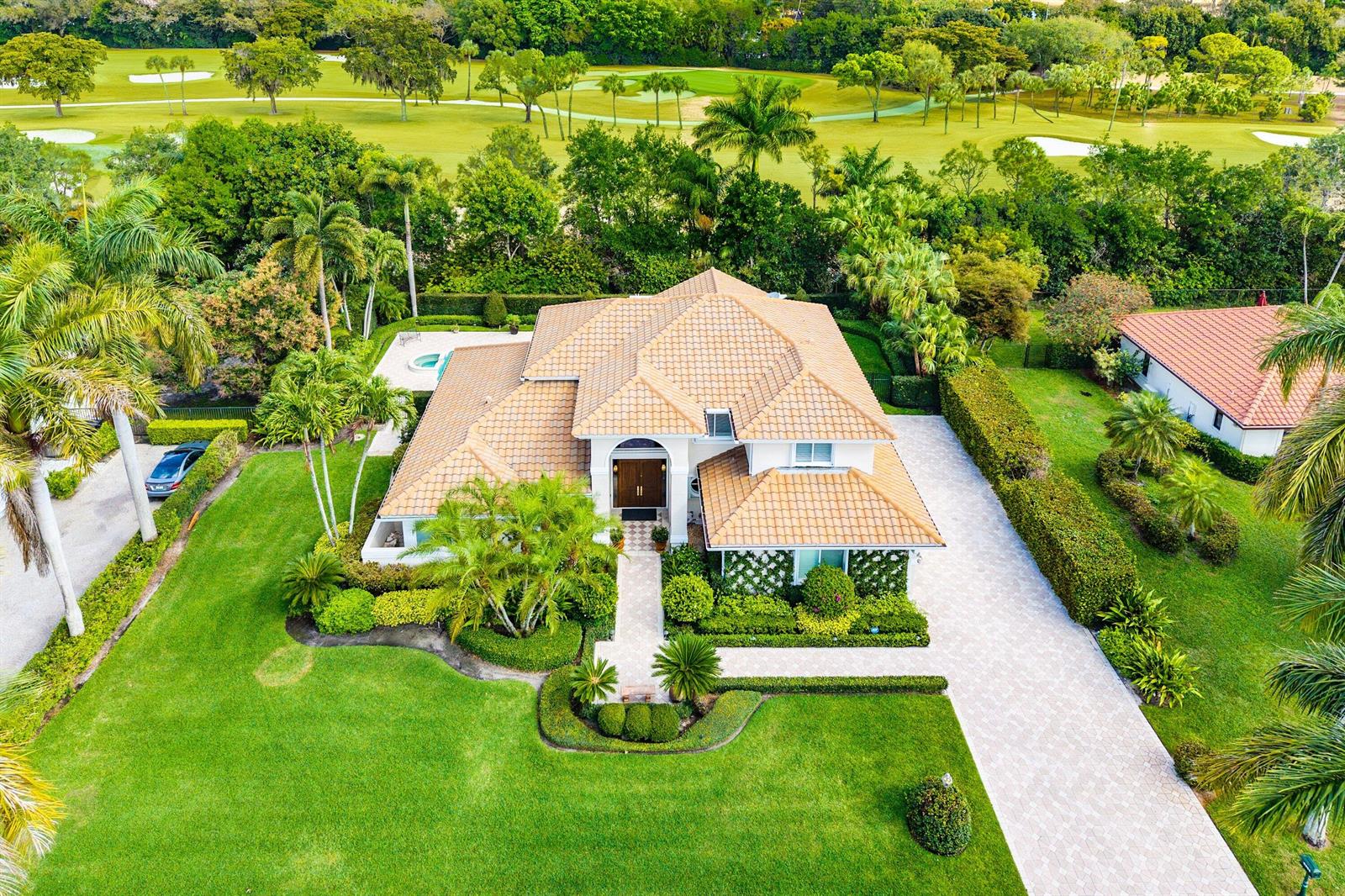 A kitchen features a wooden island, white cabinetry, stainless steel appliances, and a crystal chandelier — 4361 Gleneagles Drive, Boynton Beach FL 33436, BOYNTON BEACH, FL