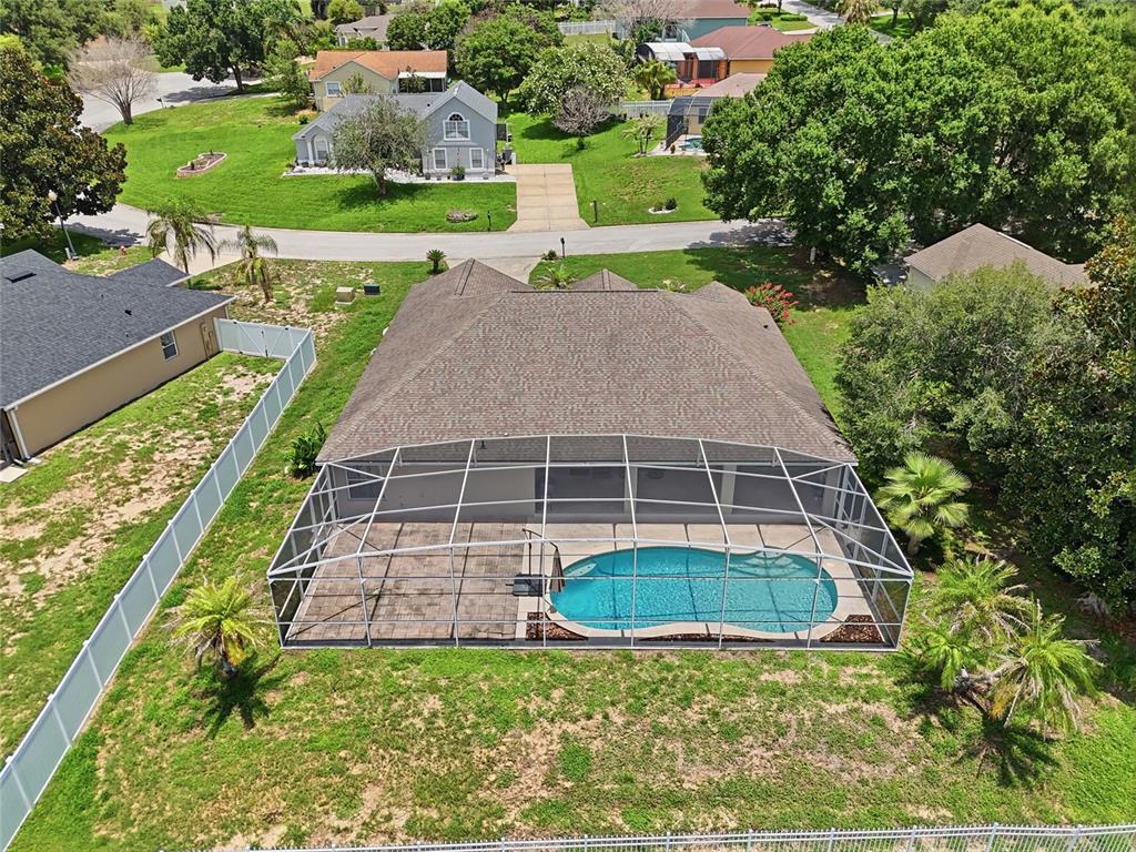 An aerial view shows a house with a screened-in pool and patio in the backyard — 13042 SUNWOOD COURT, CLERMONT, FL