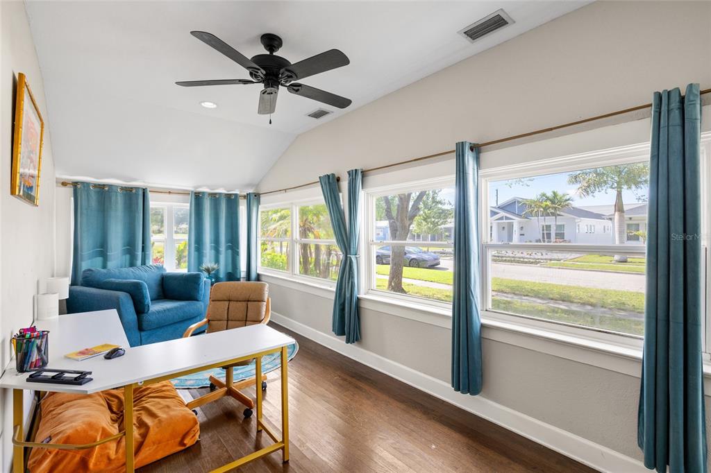A home office features a white desk, blue curtains, hardwood floors, and a ceiling fan — 466 36TH AVENUE N, ST PETERSBURG, FL