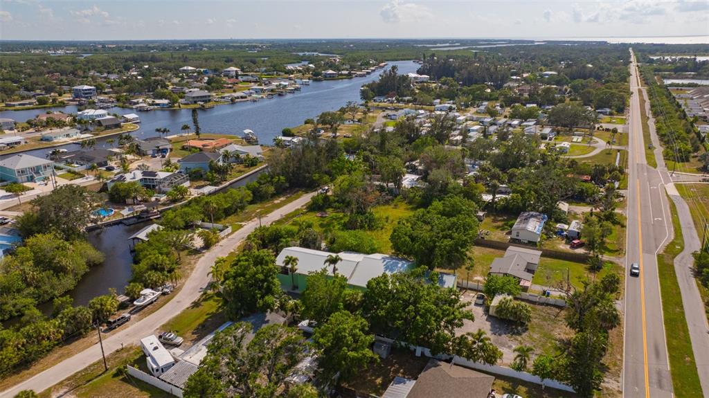 An aerial view shows a residential area with houses, a canal, and a nearby road — 826 W SHELL POINT STREET, RUSKIN, FL