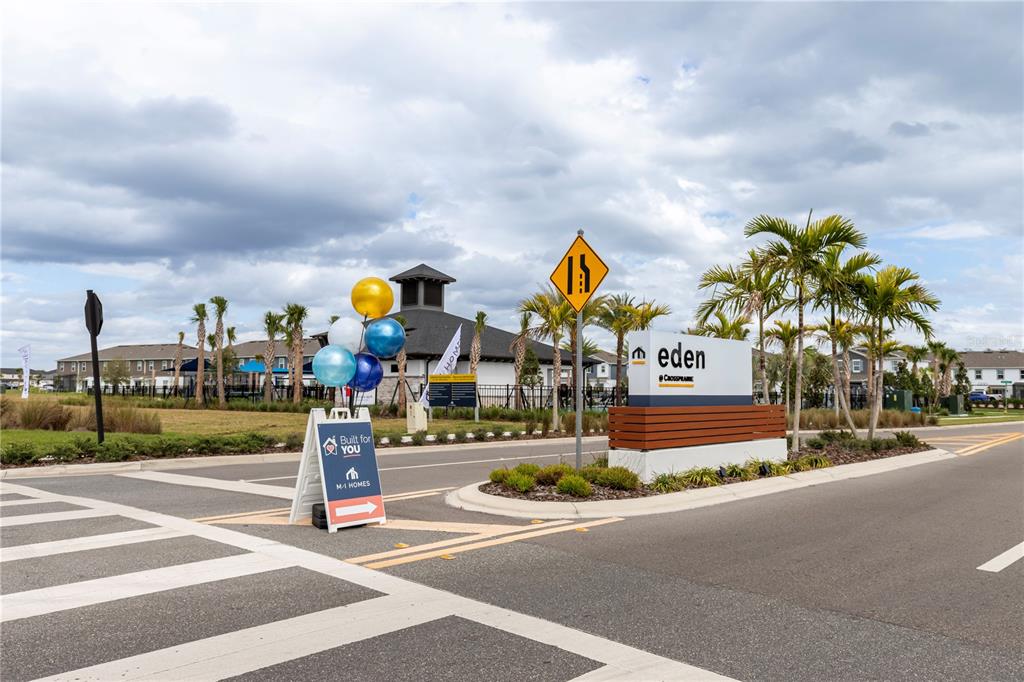 A sign for the Eden at Crosspark community stands near a crosswalk and palm trees — 5060 RAIN SHADOW DRIVE, ST CLOUD, FL