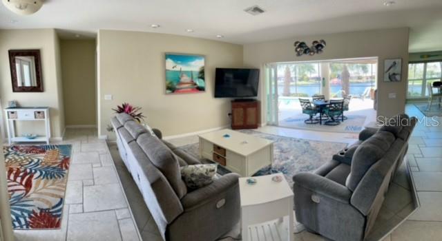 A living room with gray sofas, a coffee table, and a view of a pool — 501 BAL HARBOR BOULEVARD, PUNTA GORDA, FL