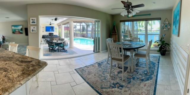 A dining area with a round table opens to a pool patio through sliding doors — 501 BAL HARBOR BOULEVARD, PUNTA GORDA, FL