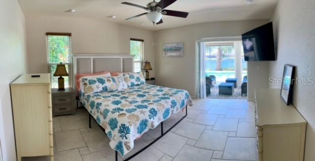 A bedroom features a bed with a seashell-patterned quilt, tiled floors, and a ceiling fan — 501 BAL HARBOR BOULEVARD, PUNTA GORDA, FL