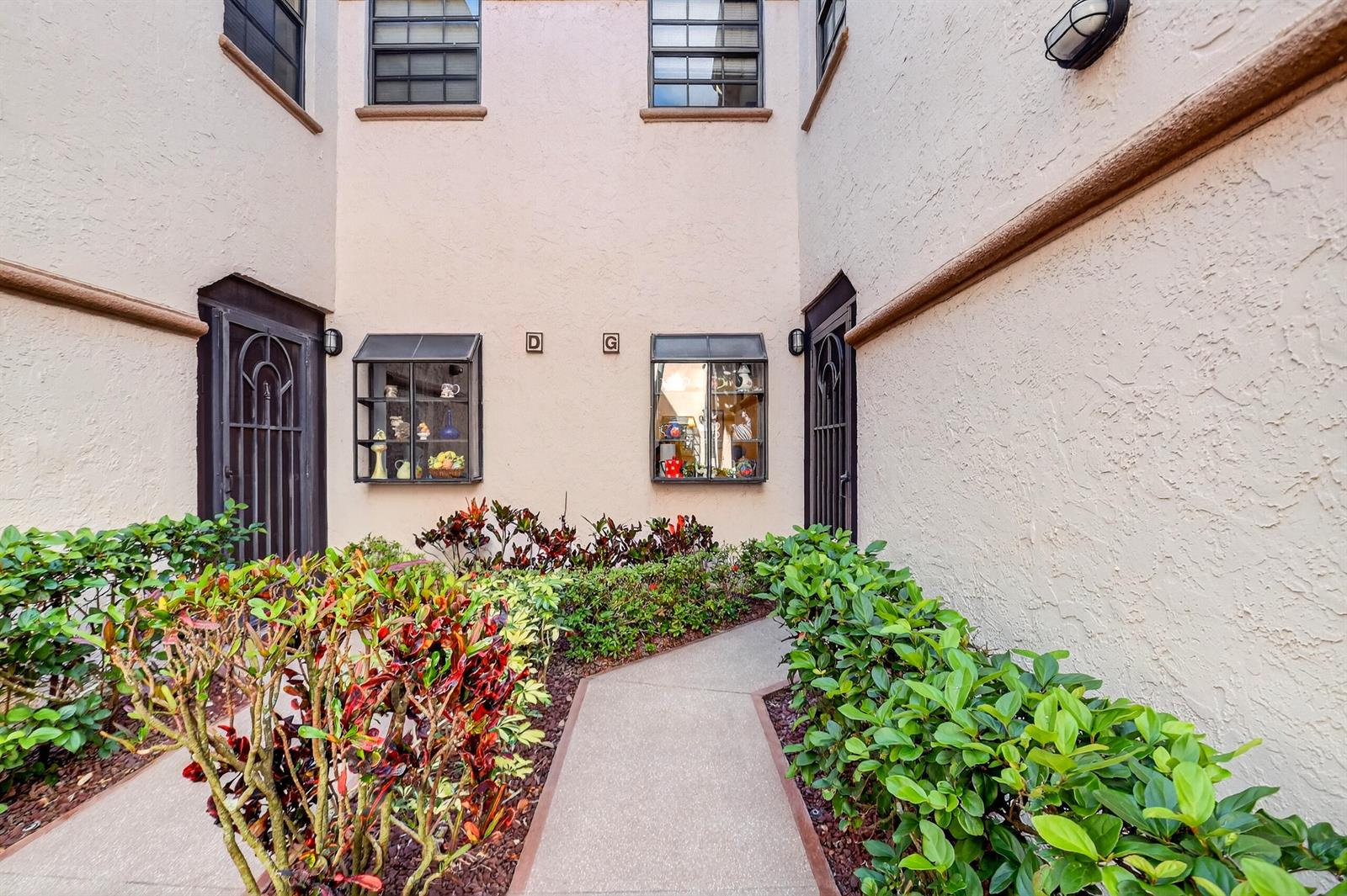 A concrete walkway leads to two building entrances with display windows and landscaping — 5188 Europa Drive # G, Boynton Beach FL 33437, BOYNTON BEACH, FL