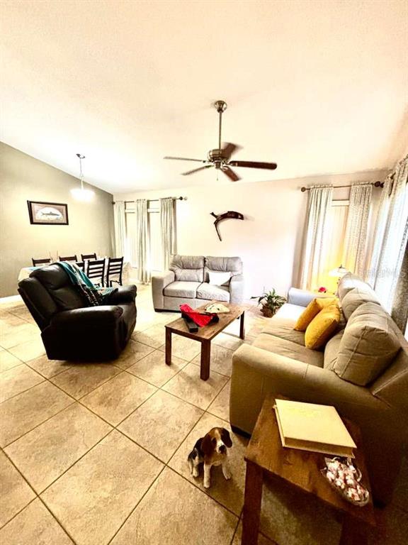 A dining room features a table with chairs, a framed fish print, and window curtains — 14224 RENSSELAER ROAD, ORLANDO, FL