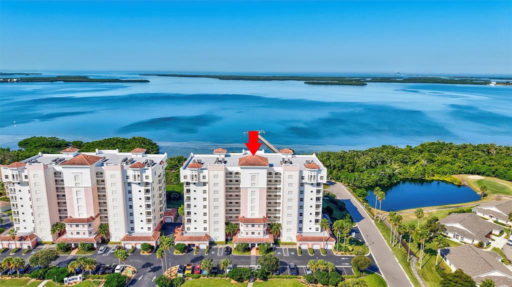 An aerial view shows a large multi-story residential building complex situated near a coastal bay — 2925 TERRA CEIA BAY BOULEVARD UNIT 2703, PALMETTO, FL