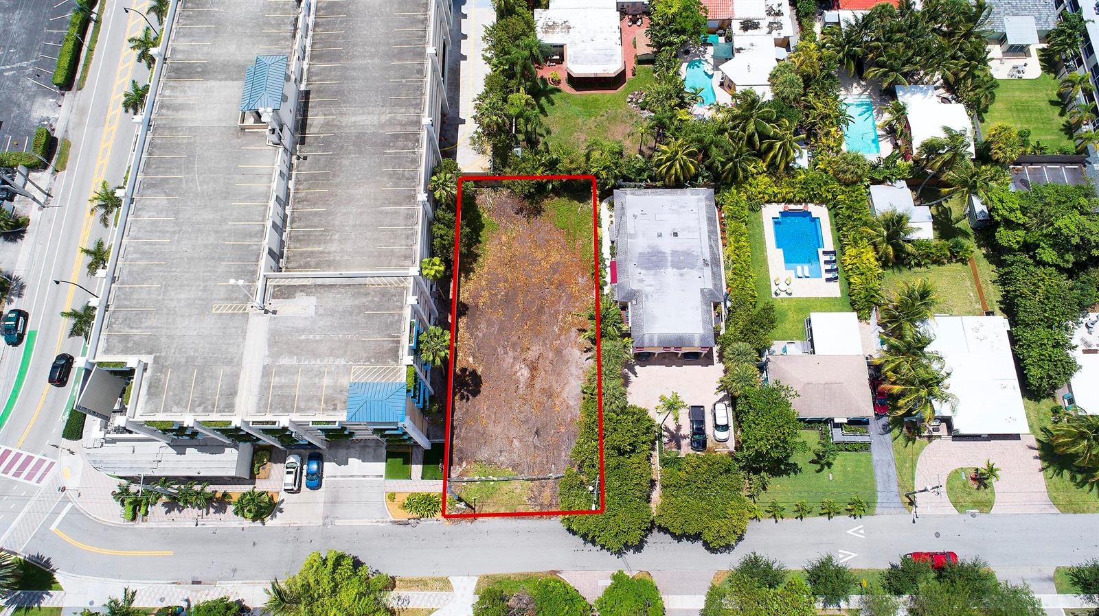 An aerial view shows a vacant rectangular lot situated between a parking garage and houses — 1956 NE 2nd Street, Deerfield Beach FL 33441, DEERFIELD BEACH, FL