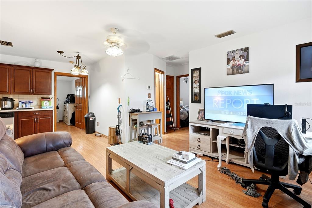 A living room features a brown sofa, a wooden coffee table, and a television console — 7301 8TH STREET N, ST PETERSBURG, FL