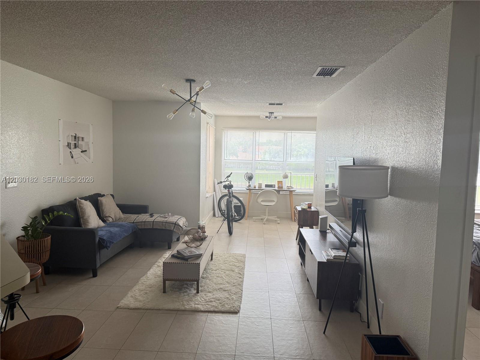 A laundry closet with white louvered sliding doors contains a washer, dryer, and shelving — 3330 N Pinewalk Dr N # 1623, Margate FL 33063, MARGATE, FL