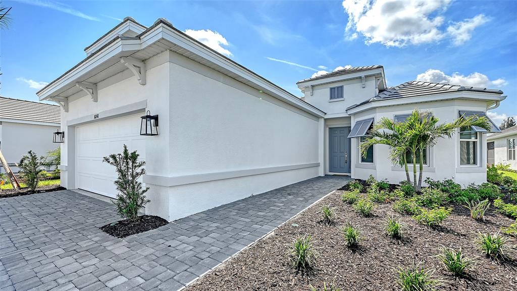 A single-story house features a white stucco exterior, a paved driveway, and a front entrance — 10248 SILENT NIGHT LANE, SARASOTA, FL