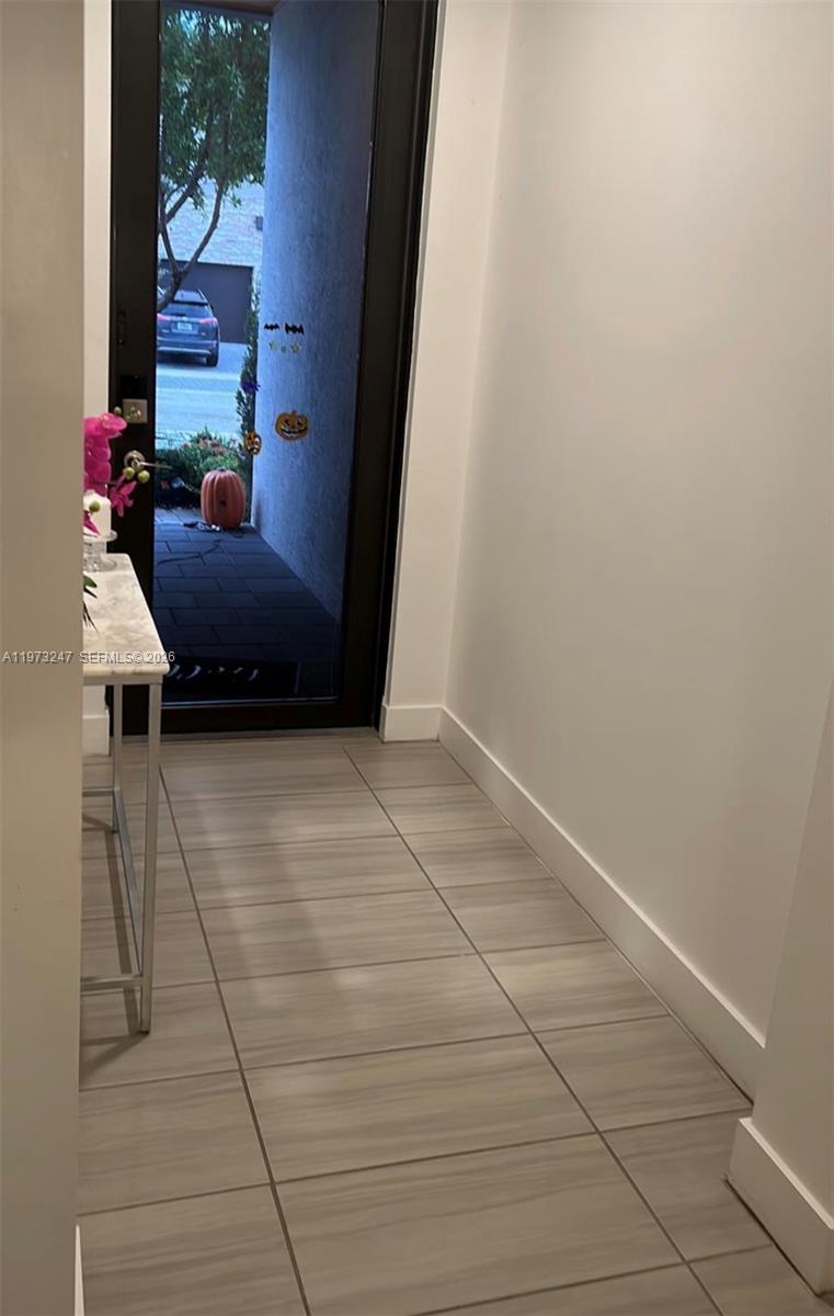 A tiled entryway features a glass front door opening to an outdoor walkway with pumpkins — 10521 NW 81st Ter, Doral FL 33178, DORAL, FL