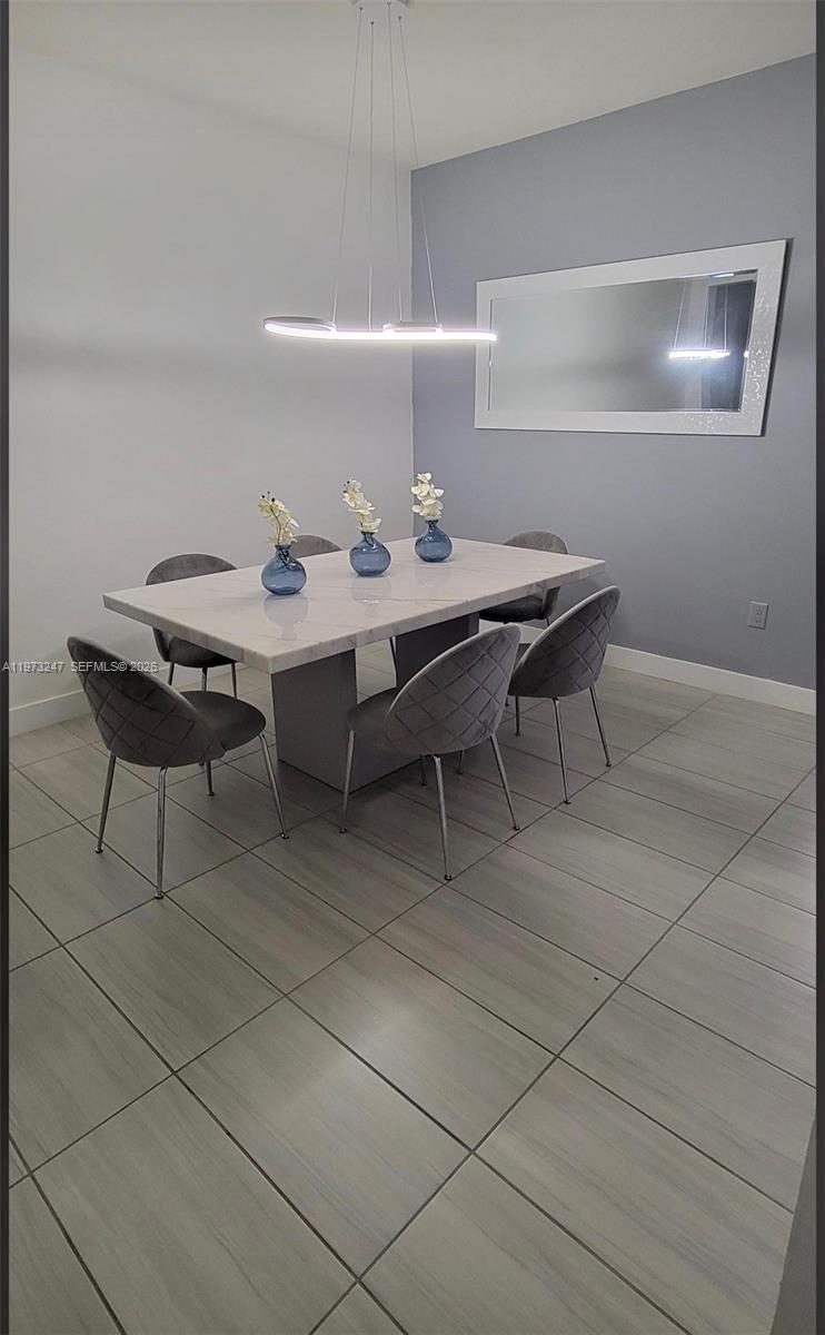A dining room features a marble-topped table, six grey chairs, and a modern pendant light — 10521 NW 81st Ter, Doral FL 33178, DORAL, FL
