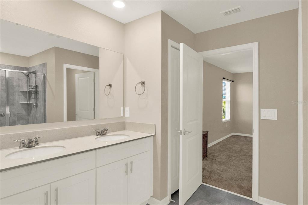 A modern kitchen features white cabinetry, a central island, stainless steel appliances, and tile flooring — 271 INMAN BOULEVARD, WINTER HAVEN, FL