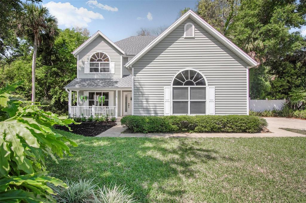 A two-story house with gray vinyl siding, a front porch, and a large arched window — 9 WHITEHALL COURT, FLAGLER BEACH, FL