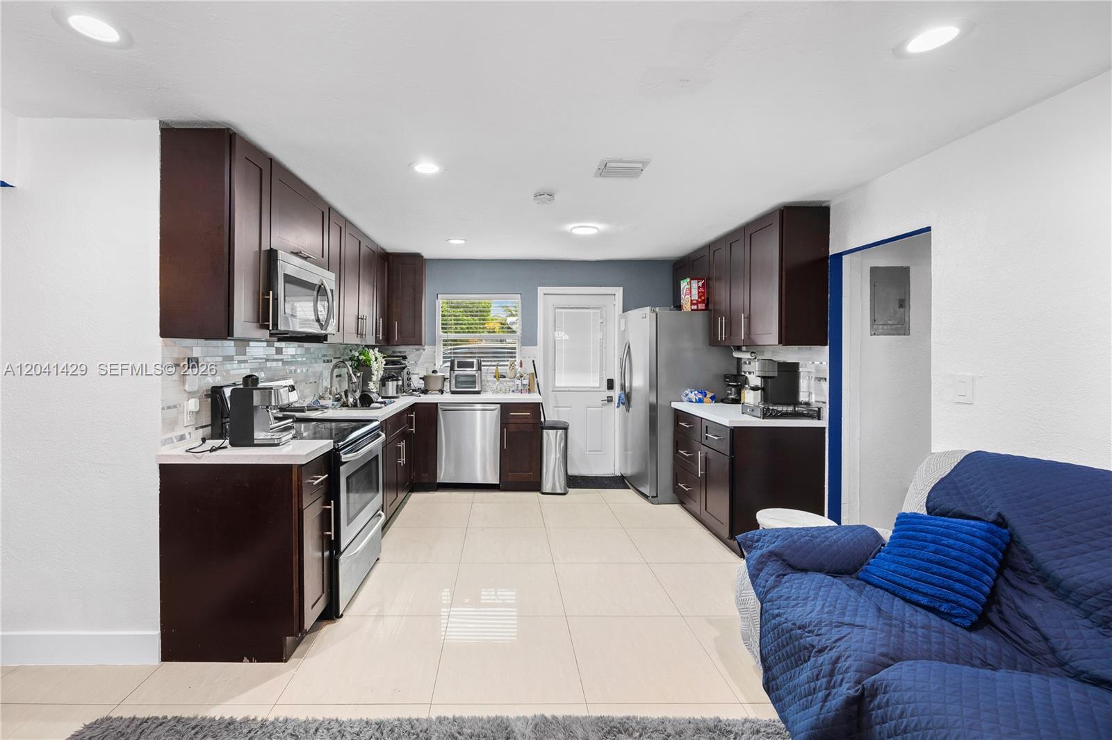A kitchen features dark wood cabinets, stainless steel appliances, and light-colored tile flooring — 1610 S 22nd Ave, Hollywood FL 33020, HOLLYWOOD, FL