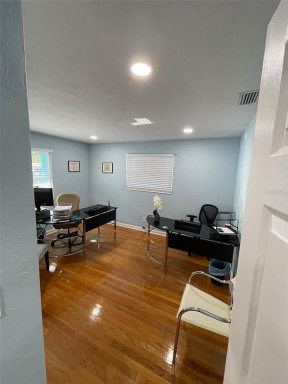 An office room features light blue walls, hardwood flooring, two desks, and a window — 5741 9TH AVENUE N, ST PETERSBURG, FL