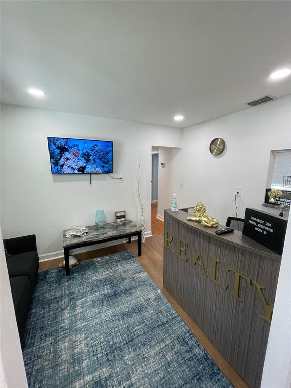A small office reception area features a blue rug, a desk, and a wall-mounted television — 5741 9TH AVENUE N, ST PETERSBURG, FL