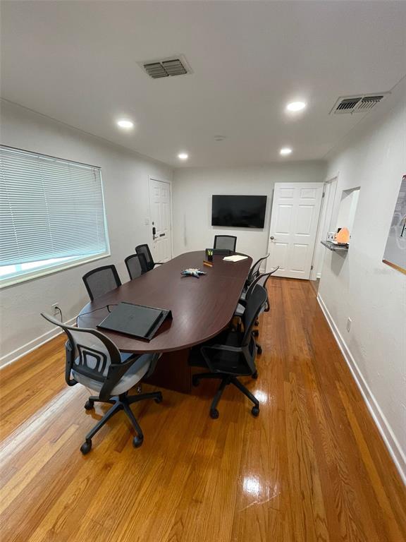 A conference room features a dark wood oval table, black office chairs, and hardwood floors — 5741 9TH AVENUE N, ST PETERSBURG, FL