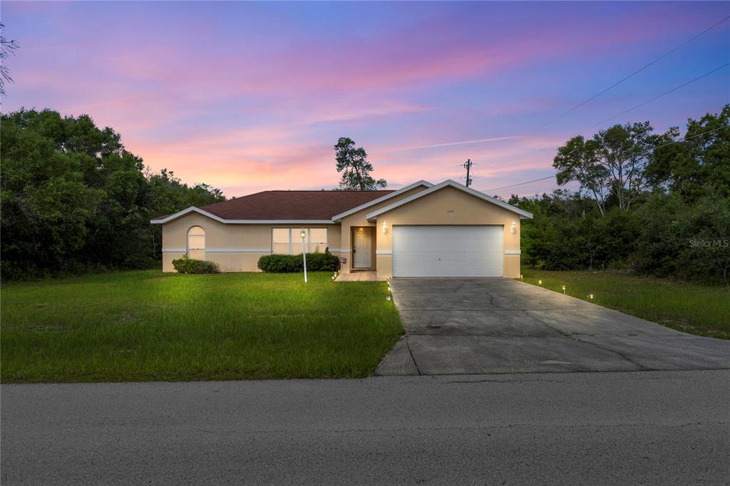 A single-story house with a tan exterior, a brown roof, and a concrete driveway — 14476 SW 29TH TERRACE, OCALA, FL