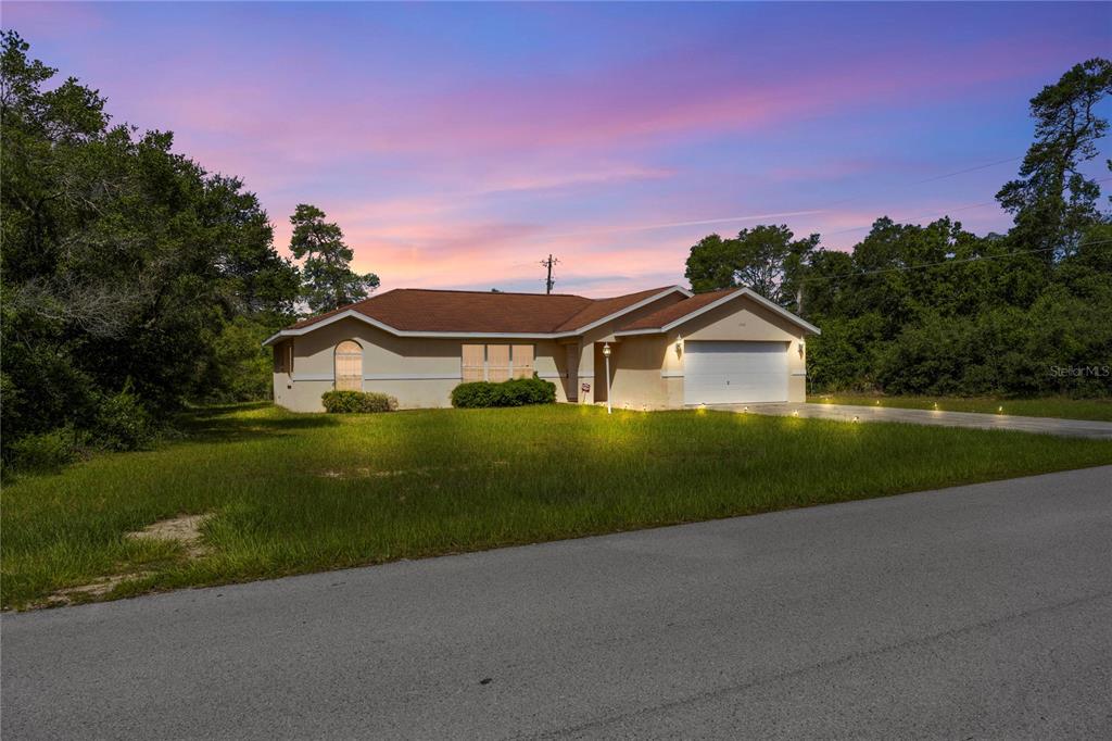 A single-story house with a tan exterior and a two-car garage sits on a lawn — 14476 SW 29TH TERRACE, OCALA, FL