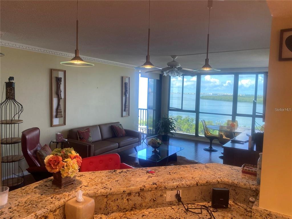 A living room with a granite breakfast bar overlooks a balcony and a water view — 7100 SUNSHINE SKYWAY LANE S UNIT 906, ST PETERSBURG, FL