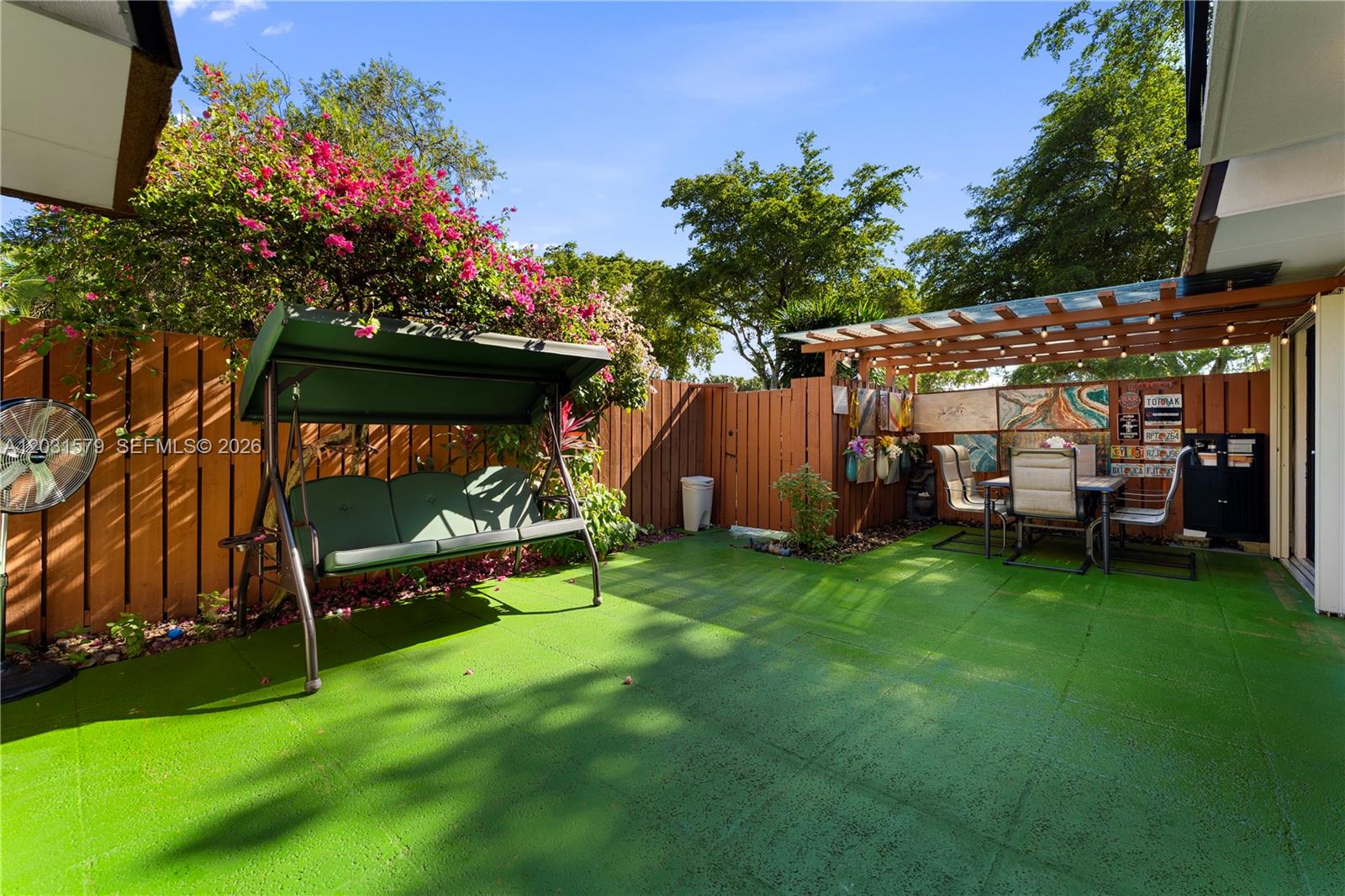 A backyard patio features a green floor, a swing, and a covered dining area — 9118c 20th ct, Davie FL 33324, DAVIE, FL