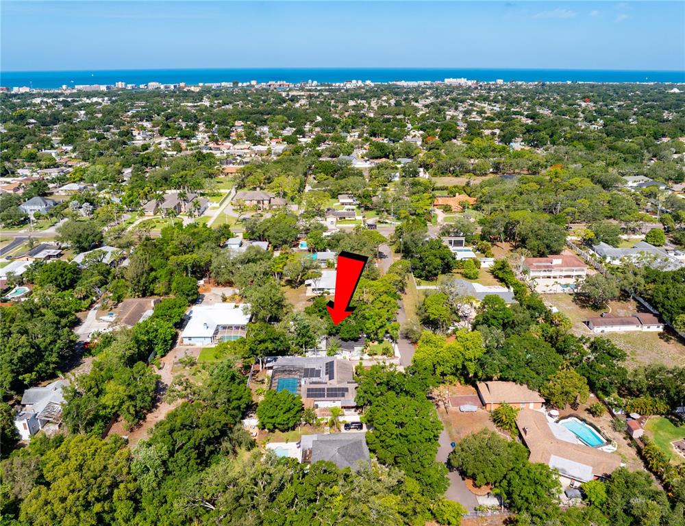 An aerial view shows a residential neighborhood with a red arrow pointing to a house — 13012 96TH AVENUE, SEMINOLE, FL