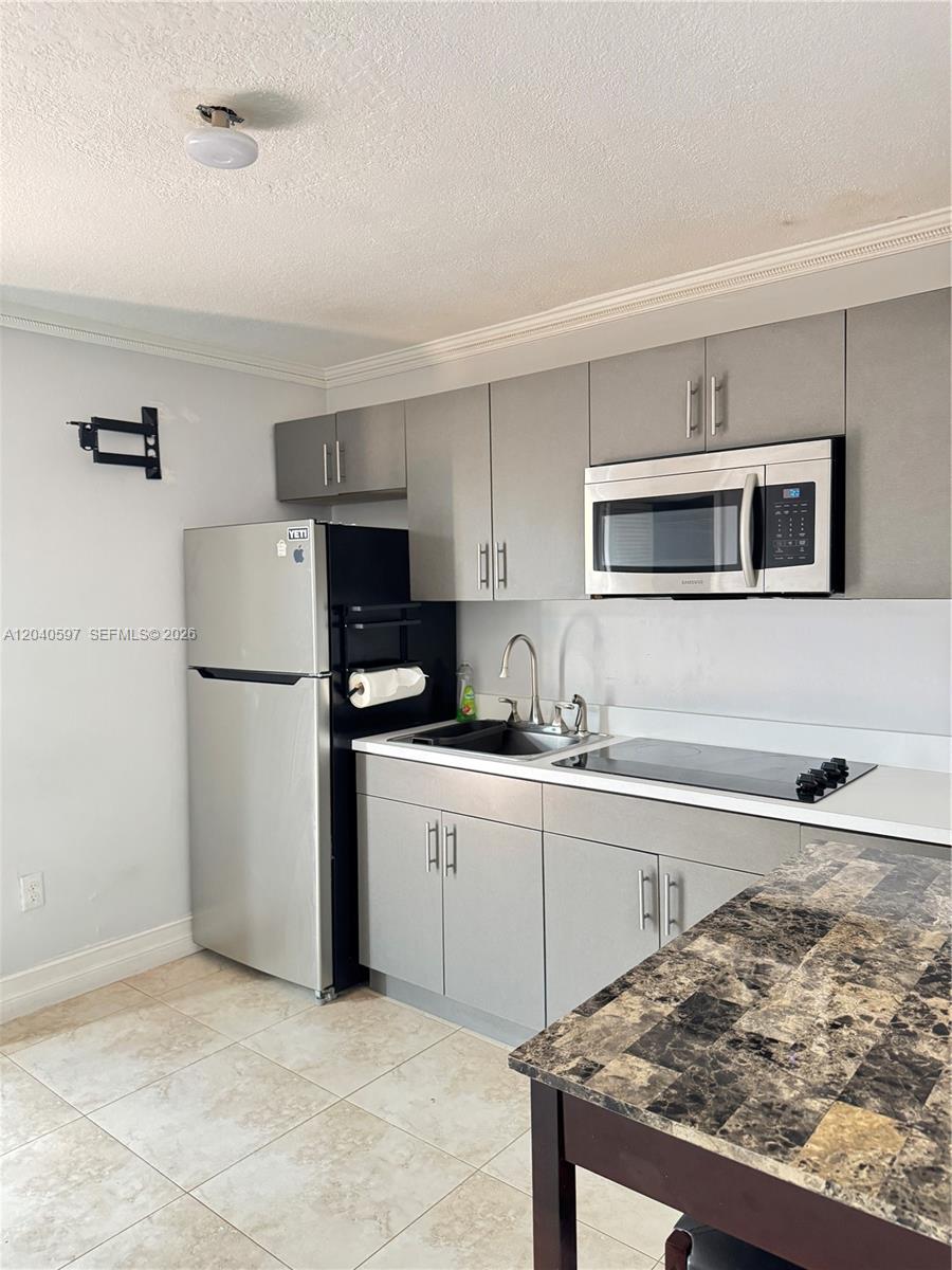 A kitchen features gray cabinets, stainless steel appliances, and a dark granite countertop — 11340 SW 41st Ter, Miami FL 33165, MIAMI, FL