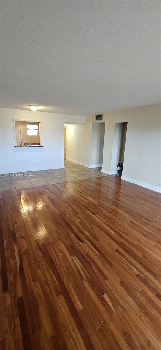 An interior view shows a living area with hardwood floors transitioning to tile near a kitchen — 410 NW 68th Ave # 509, Plantation FL 33317, PLANTATION, FL