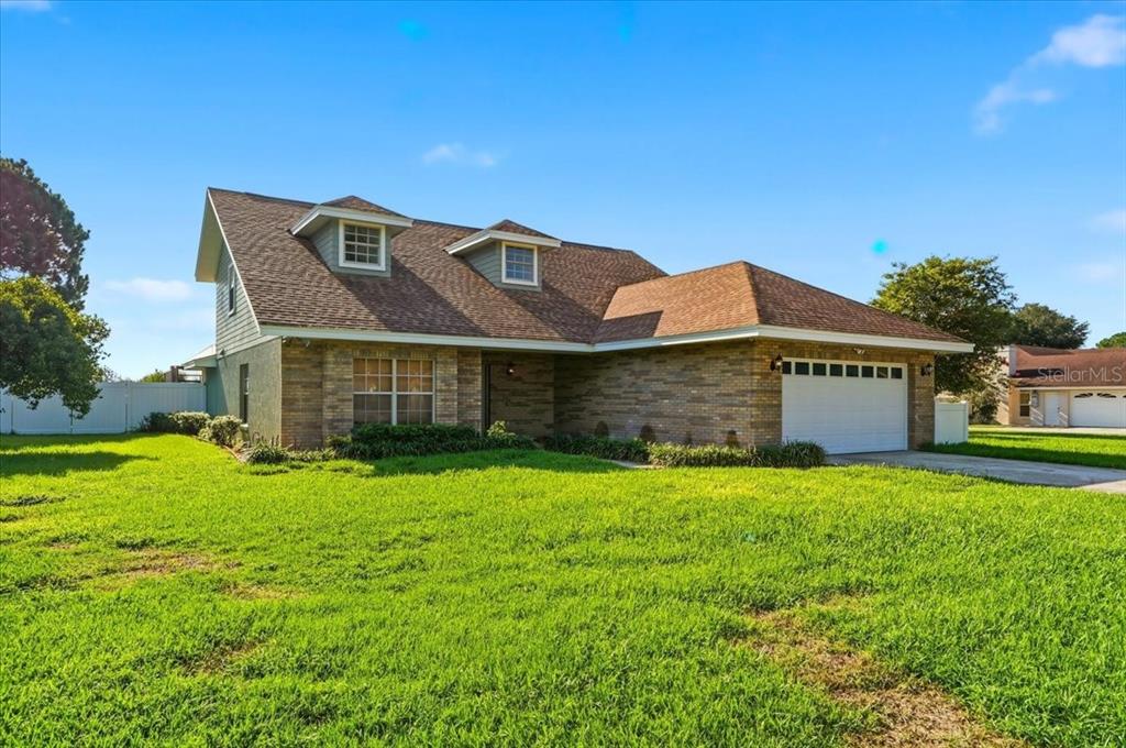 A two-story brick house with a brown shingled roof and a two-car garage — 814 CARLTON COURT, WINTER HAVEN, FL