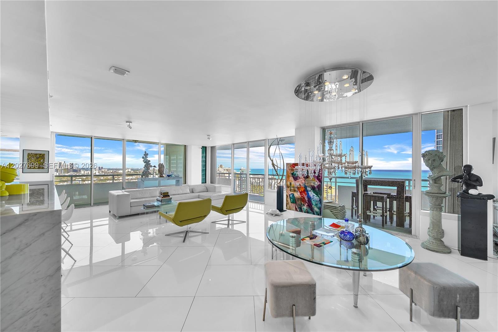 A bright, open-concept living and dining area features white tile floors and floor-to-ceiling windows — 400 S Pointe Dr # 2310, Miami Beach FL 33139, MIAMI BEACH, FL