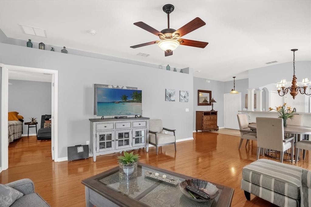 A living room with hardwood floors, a ceiling fan, and a television on a console — 3440 GRENVILLE DRIVE, WINTER HAVEN, FL