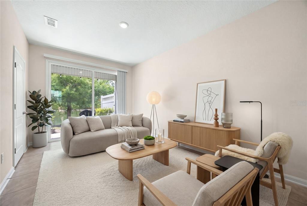 A living room features a sofa, two armchairs, a wooden coffee table, and a sliding door — 585 RUNNING WOODS STREET, ORANGE PARK, FL