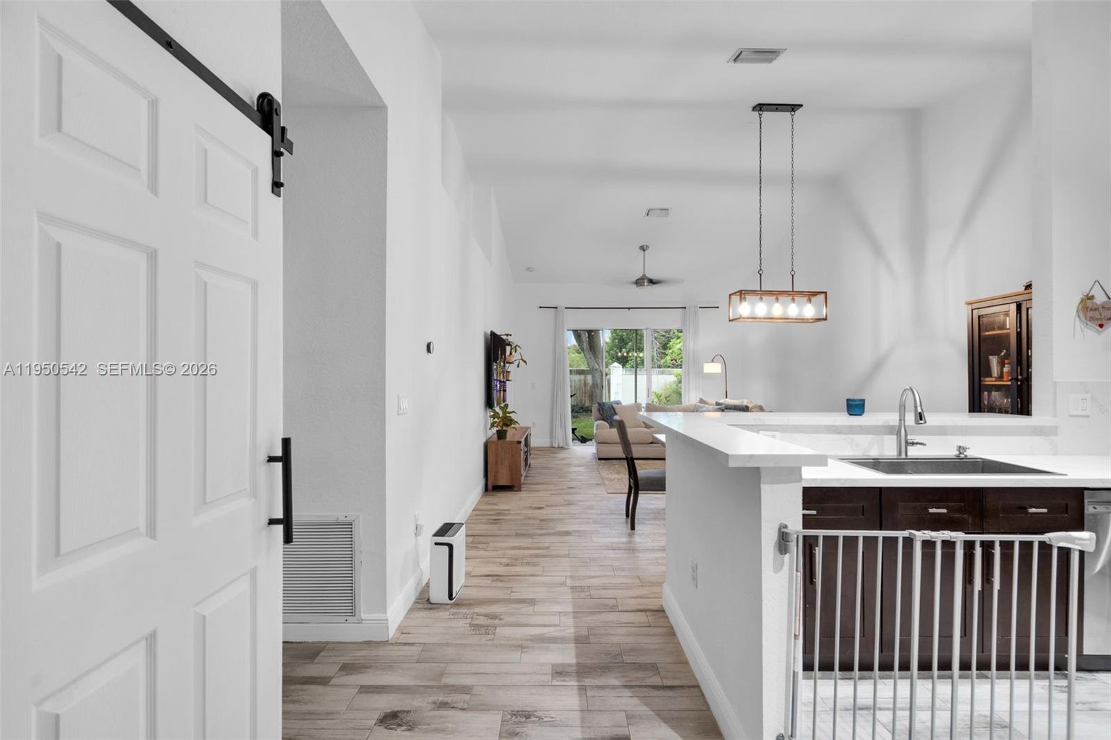 A view from a doorway looking into a kitchen and open-concept living area — 7980 S Aragon Blvd # 2, Sunrise FL 33322, SUNRISE, FL