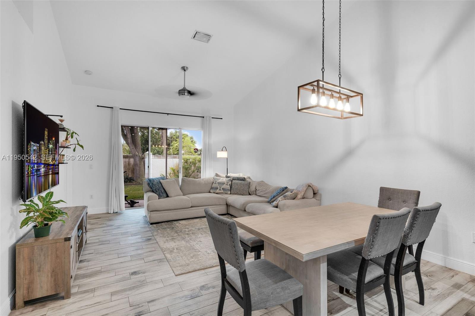 A living and dining area features a vaulted ceiling, light wood flooring, and a sectional sofa — 7980 S Aragon Blvd # 2, Sunrise FL 33322, SUNRISE, FL