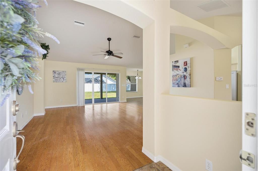 An entryway leads into a living room with hardwood floors, a ceiling fan, and sliding doors — 81 FREEMONT TURN, PALM COAST, FL