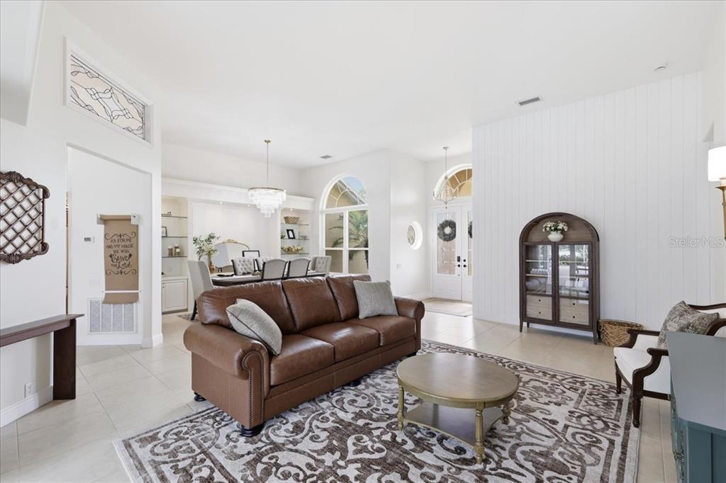 A living room with a brown leather sofa, round coffee table, and adjacent dining area — 9161 SOUTHERN COMFORT COURT, WEEKI WACHEE, FL