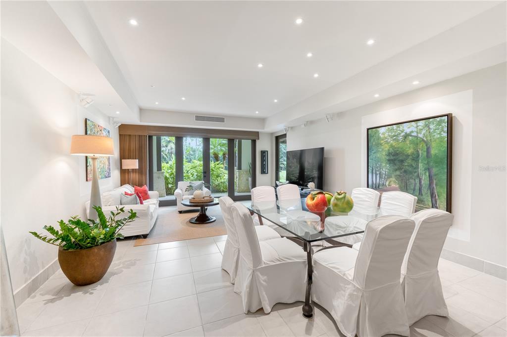 A bright dining and living area features white slipcovered furniture, a glass table, and tile flooring — Bahia Beach Golf Club LAS VERANDAS CONDOMINIUM #3119 UNIT 3119, RIO GRANDE, PR