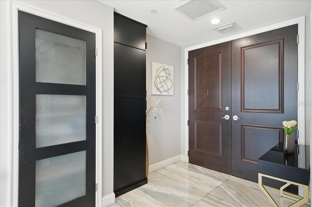 An entryway features a dark double door, a frosted glass door, and marble-look tile flooring — 449 S 12TH STREET UNIT 1804, TAMPA, FL