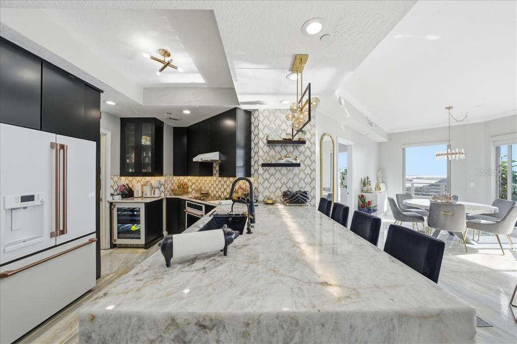 A modern kitchen features a large marble island, black cabinetry, and an adjacent dining area — 449 S 12TH STREET UNIT 1804, TAMPA, FL