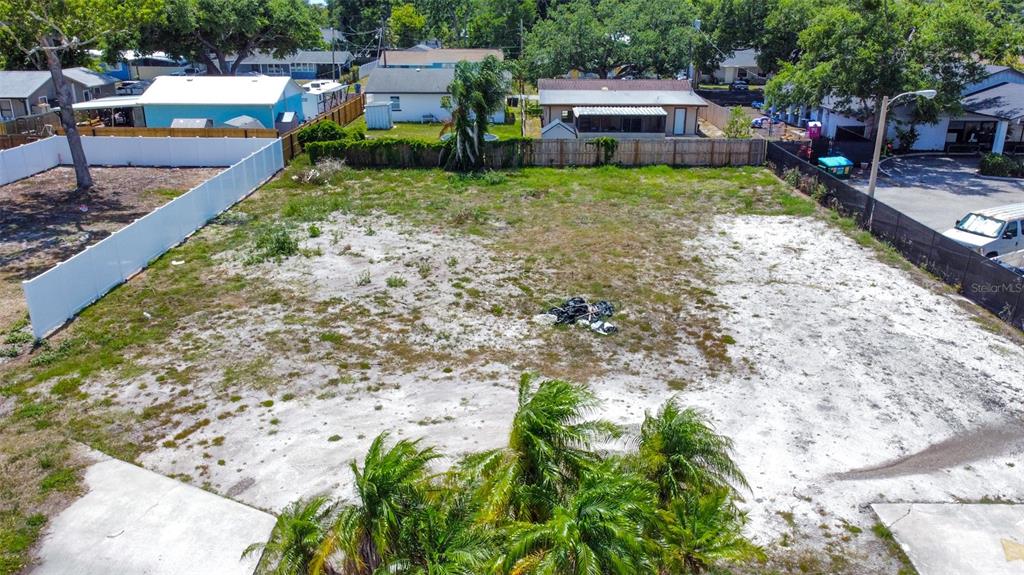 An aerial view shows a vacant, sandy rectangular lot bordered by fences and nearby houses — 1120 35TH STREET W, BRADENTON, FL