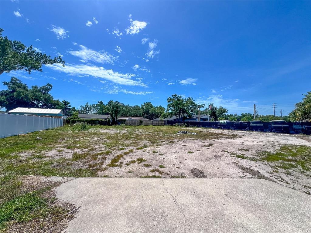 A flat, cleared, vacant lot with a concrete driveway in the foreground under a blue sky — 1120 35TH STREET W, BRADENTON, FL