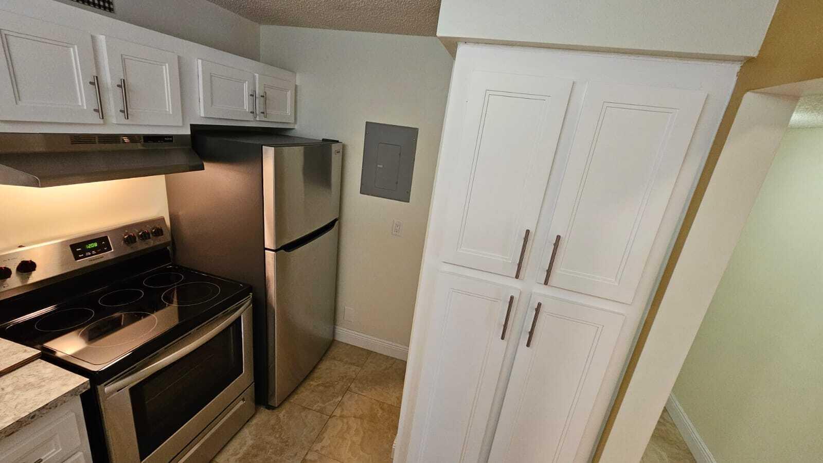 A kitchen featuring white cabinets, stainless steel appliances, and tile flooring — 205 Foxtail Drive # H3, FL 33415, FL