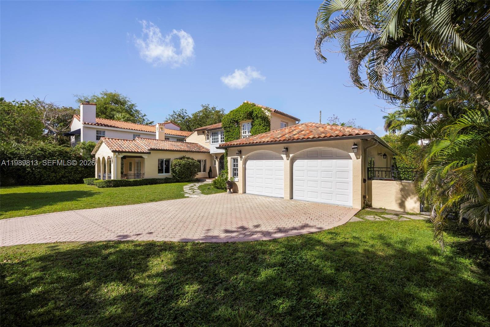 A two-story Mediterranean-style house features a paved circular driveway and an attached two-car garage — 4206 Alhambra Cir, Coral Gables FL 33146, CORAL GABLES, FL