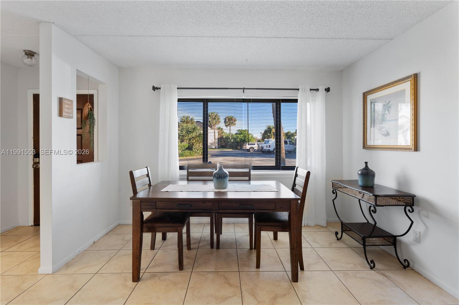 A dining room features a wooden table, four chairs, tile flooring, and a window view — 1145 N Shannon # 39, Indialantic FL 32903, INDIALANTIC, FL