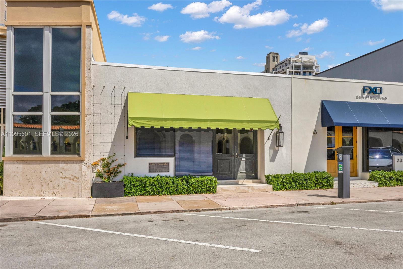 A commercial building exterior features a green awning, dark double doors, and a small garden — 337 Palermo Ave, Coral Gables FL 33134, CORAL GABLES, FL
