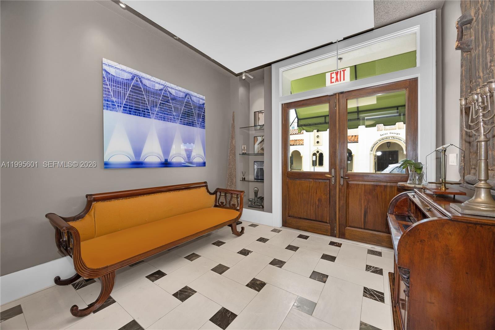 A foyer features a wooden bench, tiled floor, built-in shelves, and double doors leading outside — 337 Palermo Ave, Coral Gables FL 33134, CORAL GABLES, FL