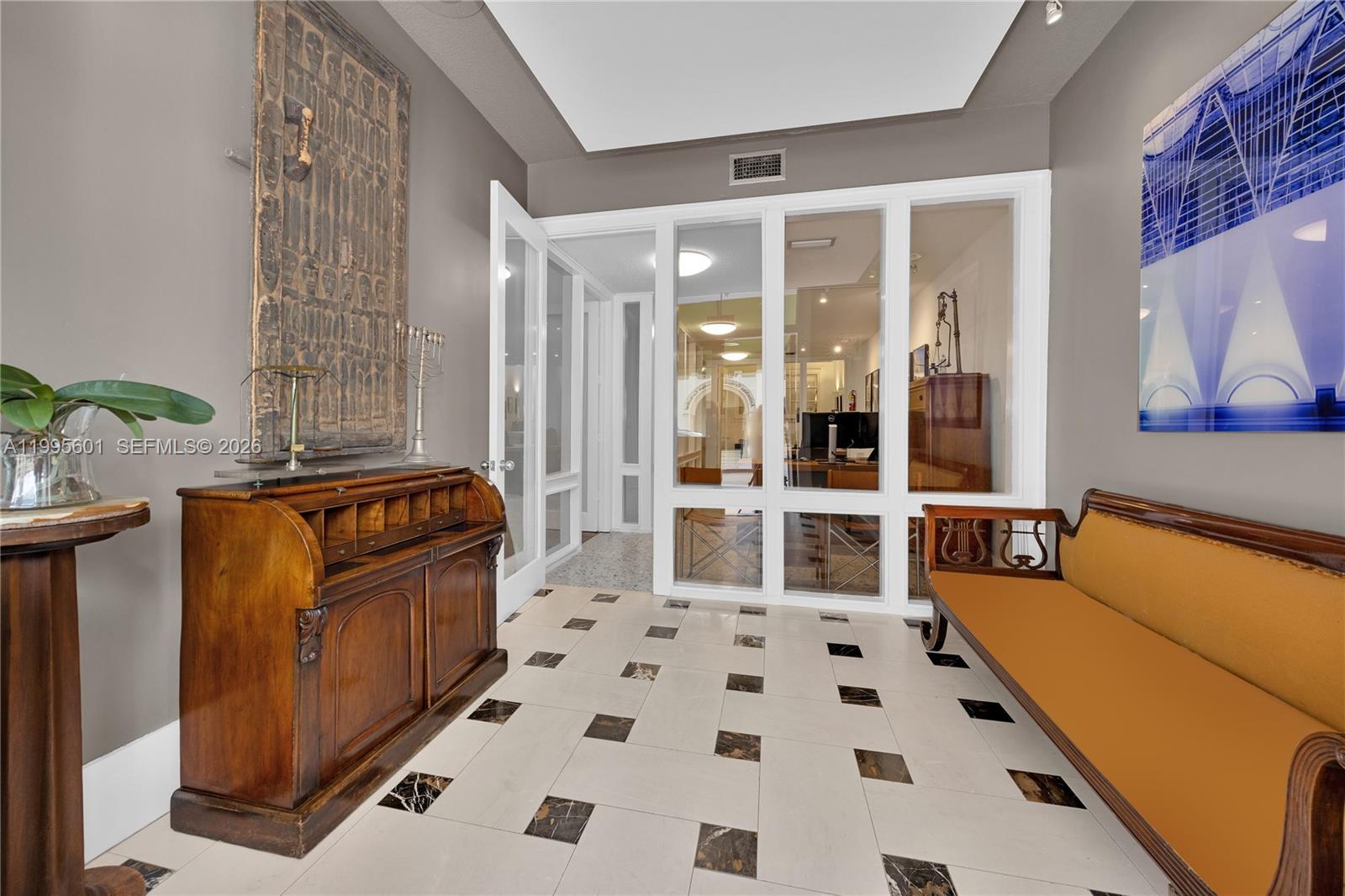 A foyer features a roll-top desk, a wooden bench, and glass-paneled walls on tile flooring — 337 Palermo Ave, Coral Gables FL 33134, CORAL GABLES, FL